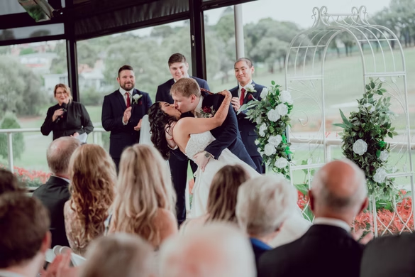 Newlyweds embracing beneath a sunlit veil